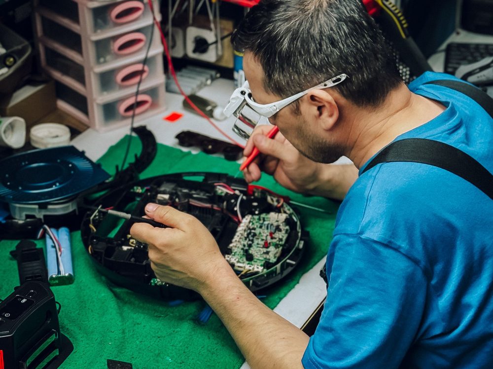 Technician testing an electronic device on a home workbench